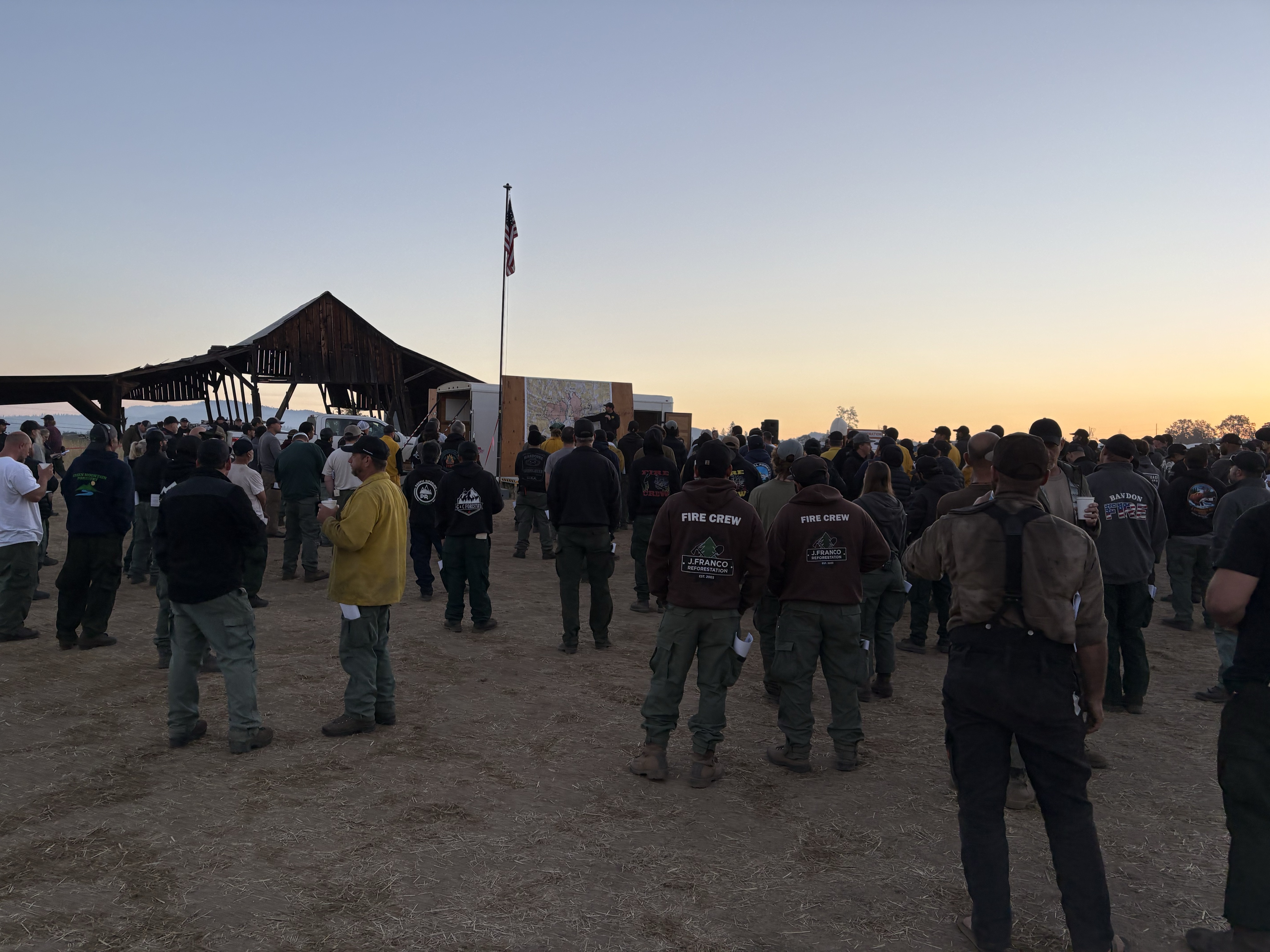 east-evans-creek-20260724-briefing-am Group of fire crew people during a morning briefing.
